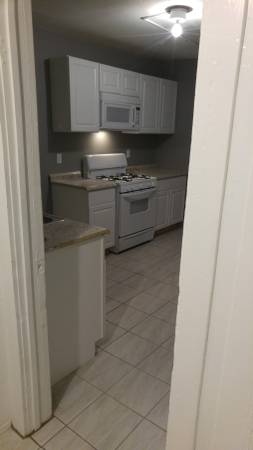 gray kitchen with white cabinets. white stove with microwave above stove