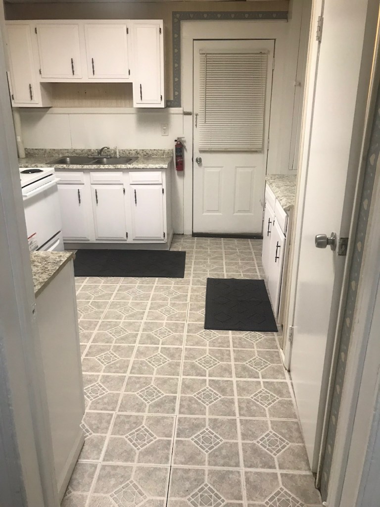 kitchen with white cabinets and door to exit