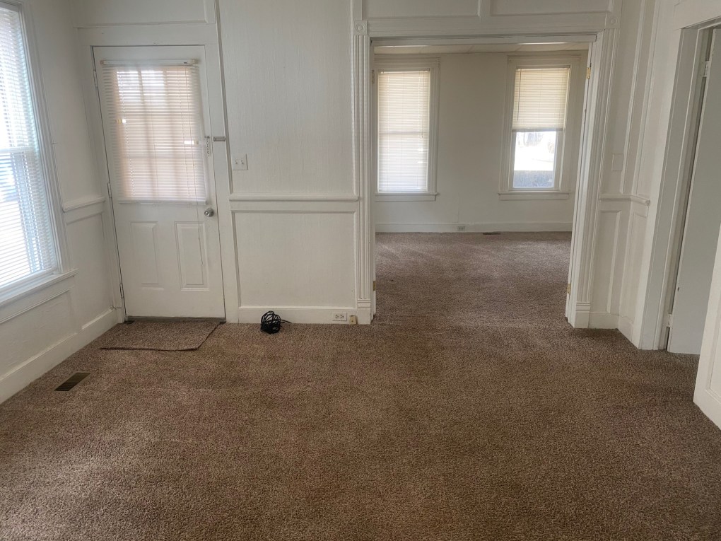 livingroom looking into bedroom. carpet through out and doorway.