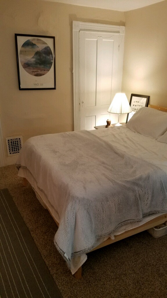 bed with white sheets and door to closet