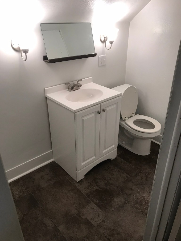 Bathroom with sink mirror and toilet