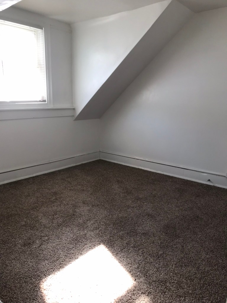 bedroom with brown carpet and window